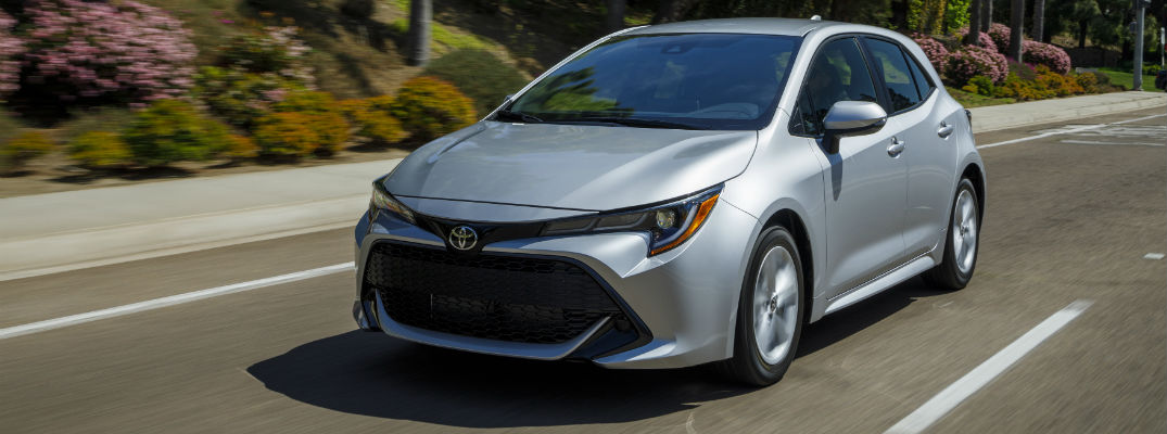 A front left quarter photo of the 2019 Toyota Corolla Hatchback in motion on the road.
