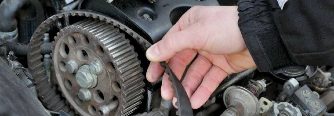 man checks belt in engine
