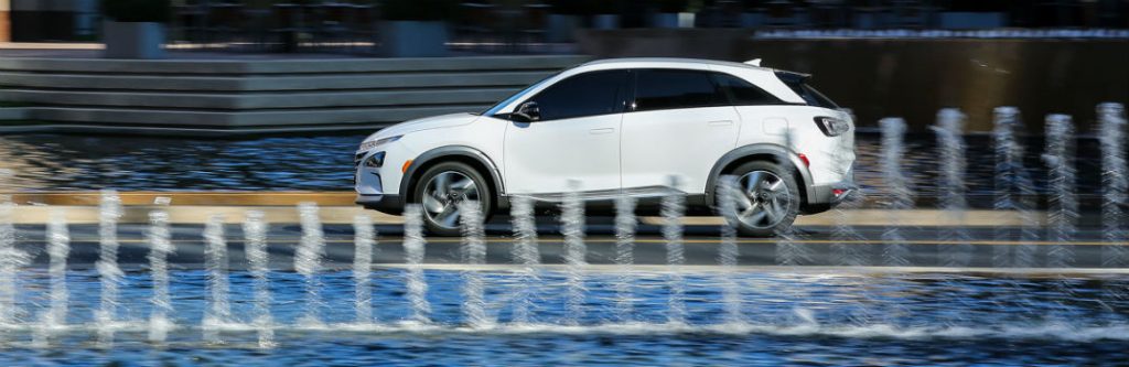 hyundai nexo driving by fountain side view