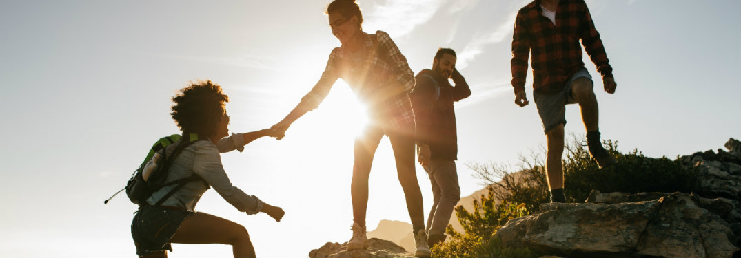 four-friends-traversing-rocky-terrain-while-hiking