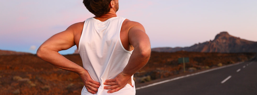 Un hombre con dolor de espalda mientras está en la carretera