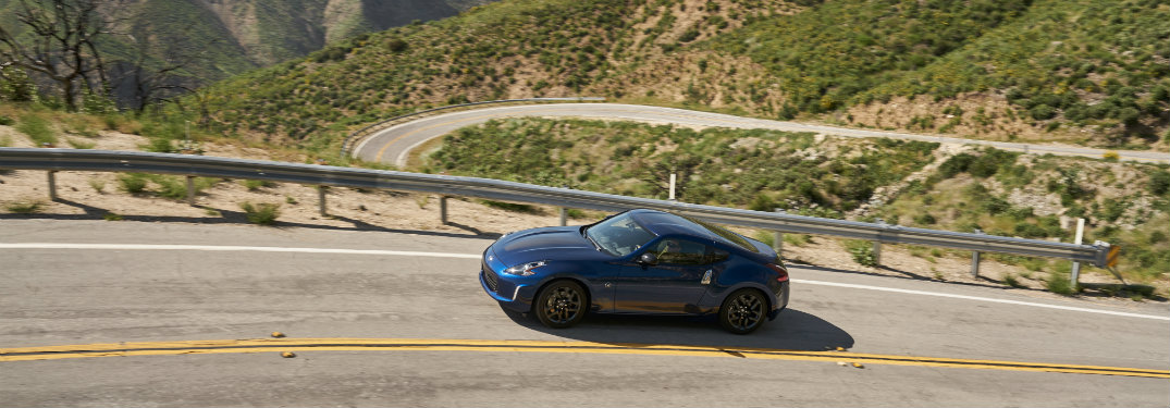 blue nissan 370z driving on mountain road