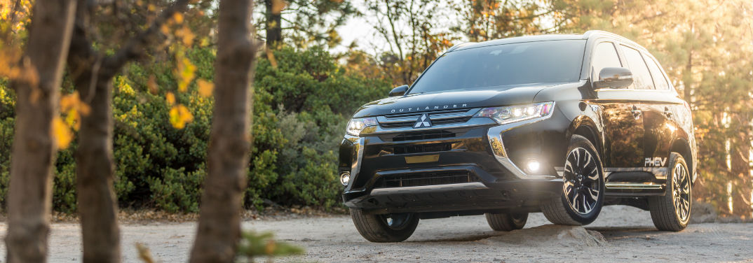 mitsubishi outlander driving over a bump in the woods
