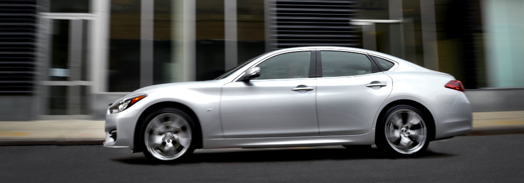 left side of silver infiniti driving in city