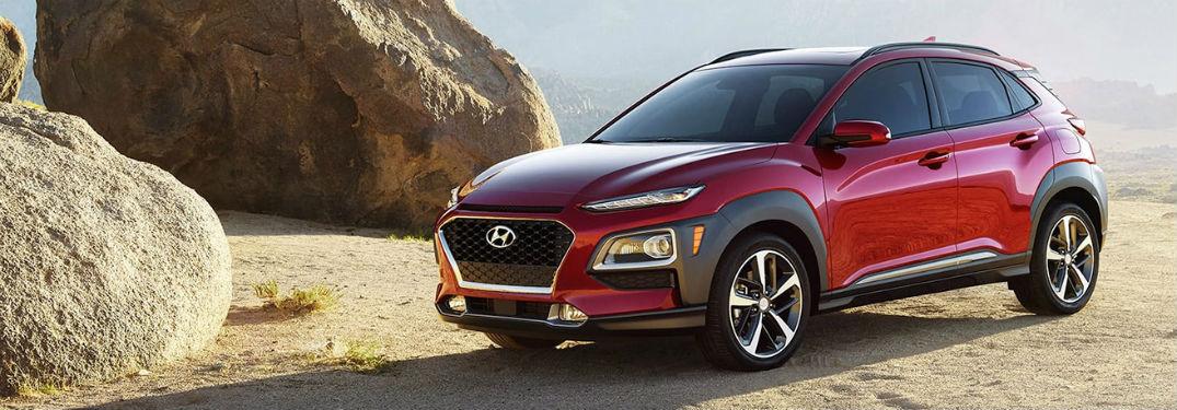 2020 Hyundai Kona red exterior front fascia driver side parked to right of large desert boulders