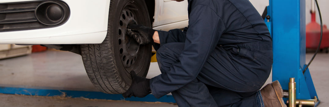 Mechanic Rotating Tires in a Service Department