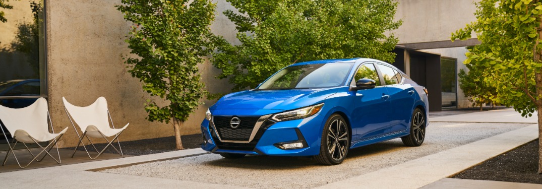 blue nissan sentra parked by a house