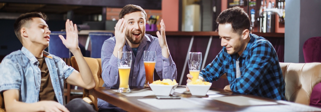 frustrated men watching sports at a bar