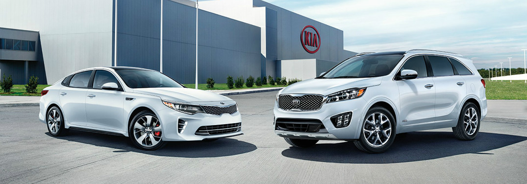two new kia models parked outside kia dealership