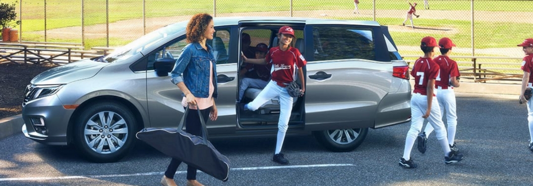 young baseball players and parent around 2018 honda odyssey minivan