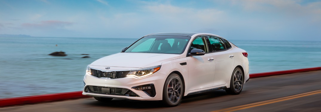 2020 Kia Optima driving down a beachside road