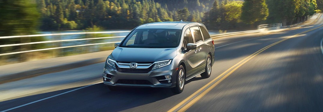 2020 Honda Odyssey Elite Lunar Silver Metallic driving down lakeside road
