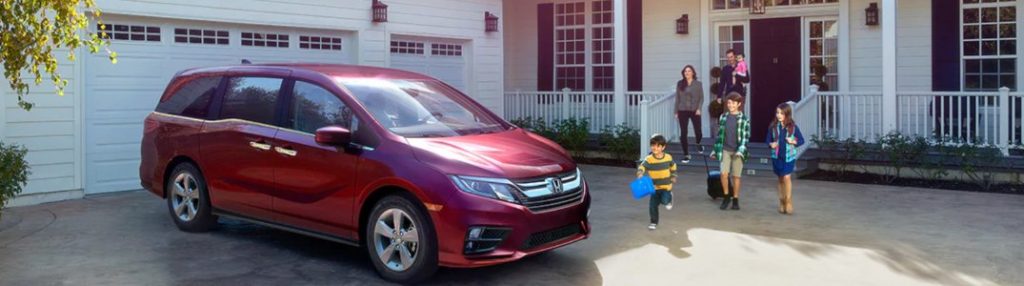A family walking toward a parked 2020 Honda Odyssey