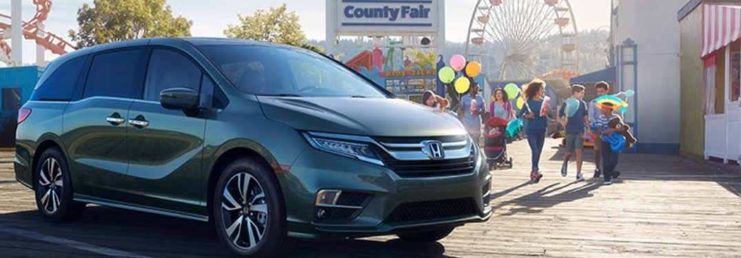 A 2020 Honda Odyssey parked in front of an amusement park