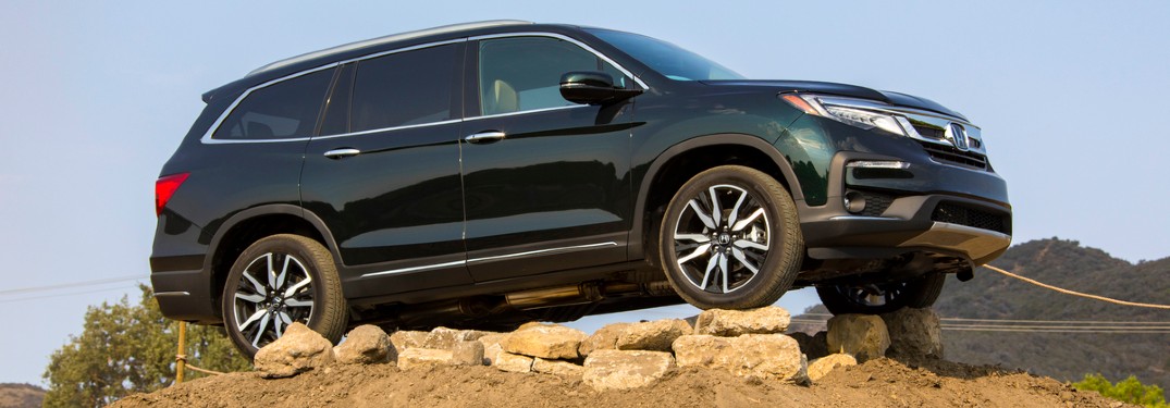 2021 Honda Pilot Elite black or dark green parked on rocks