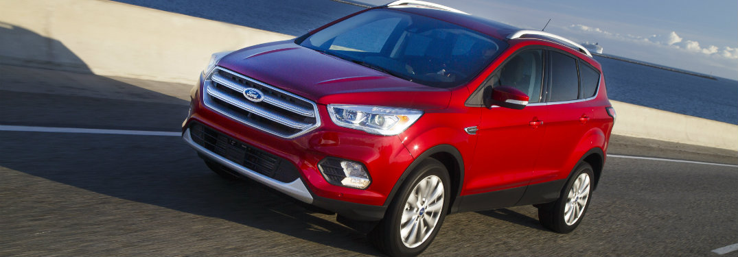 red ford escape on highway by water