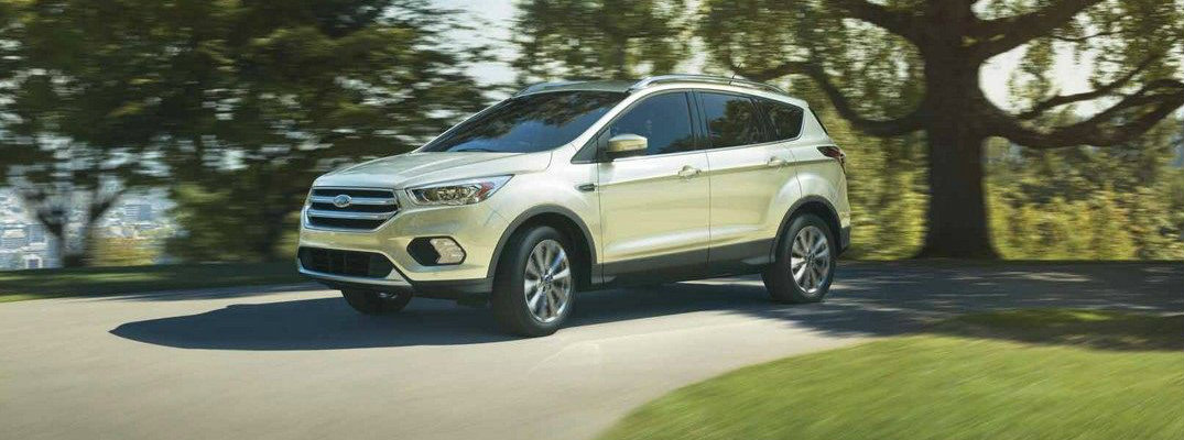 White 2018 Ford Escape driving on wooded road