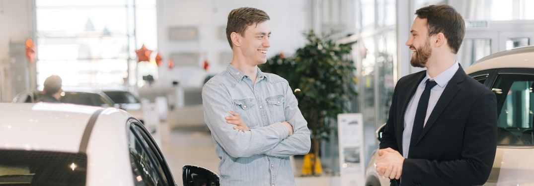 Two men talking at a car dealership