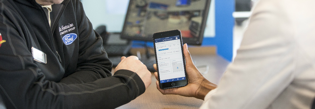 Ford employee showing someone how to use the FordPass smartphone features