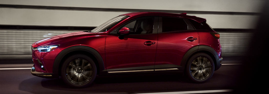 2019 Mazda CX-3 exterior drivers side profile with lights glaring and going fast