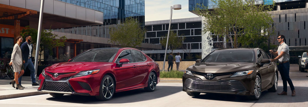 Two Toyota Camry sedans parked by a building