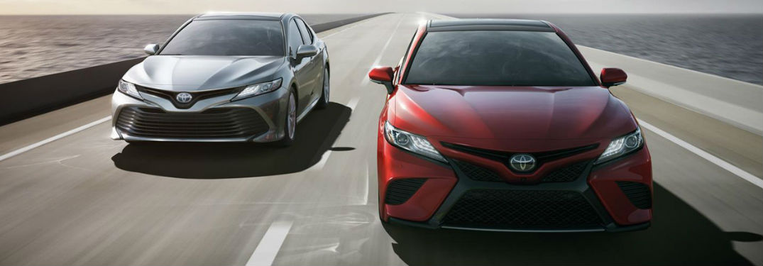 Two Toyota Camry sedans driving on a road