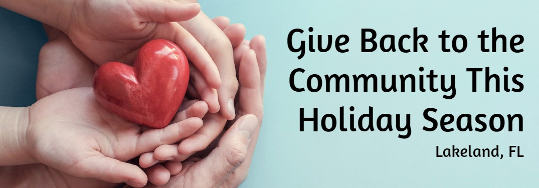 Hands holding a heart on a blue background with the text "Give back to the community this holiday season Lakeland, FL"