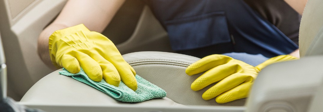 Close up of a worker cleaning a car seat