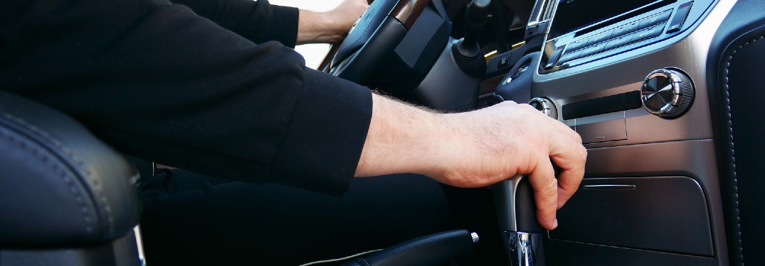 Driver's hand on the gear shift inside a vehicle