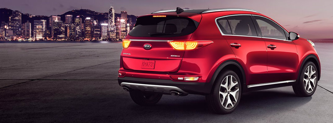 Red 2018 Kia Sportage parked with city skyline in background