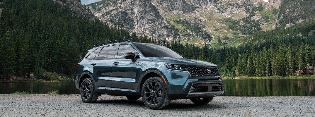 The 2021 Kia Sorento parked by a lake and mountains.