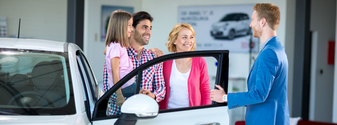 A stock photo of a family buying a new car.