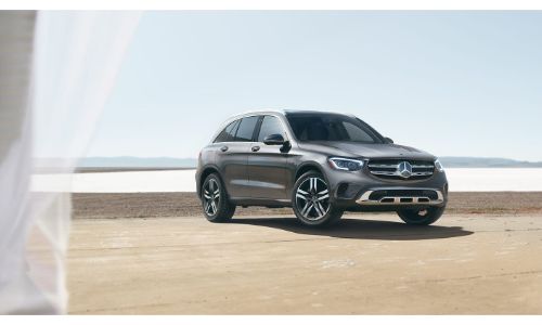 2020 Mercedes-Benz GLC SUV parked on sand in front of water seen through window with curtain on right side