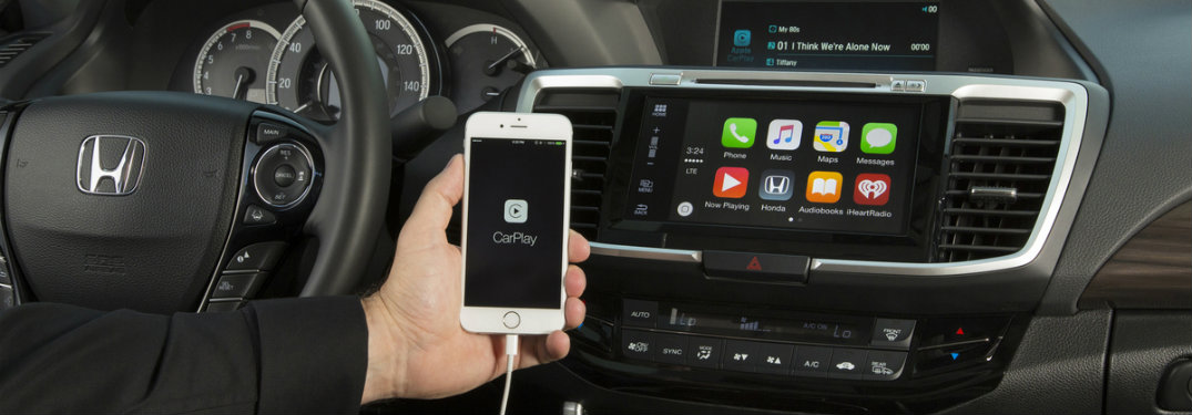 person holding phone, apple carplay monitor