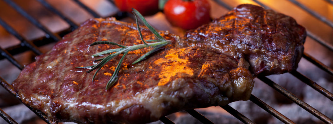 A stock photo of a steak on the grill.