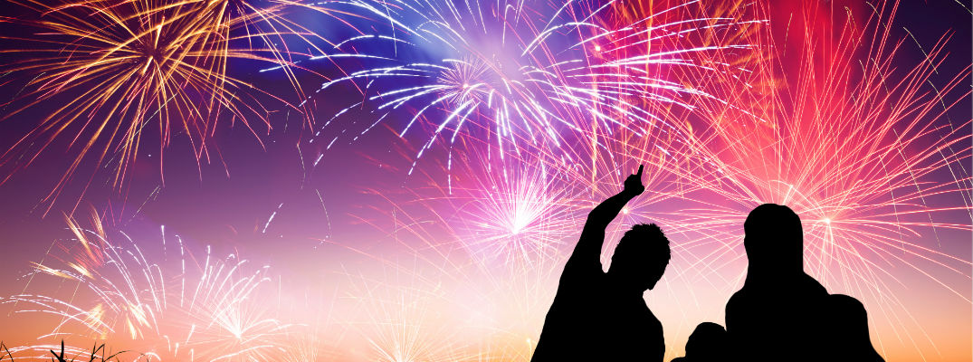 A photo illustration of a family in silhouette watching fireworks.