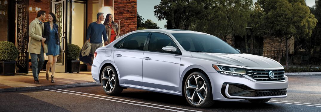 A couple walking towards a parked 2020 Volkswagen Passat