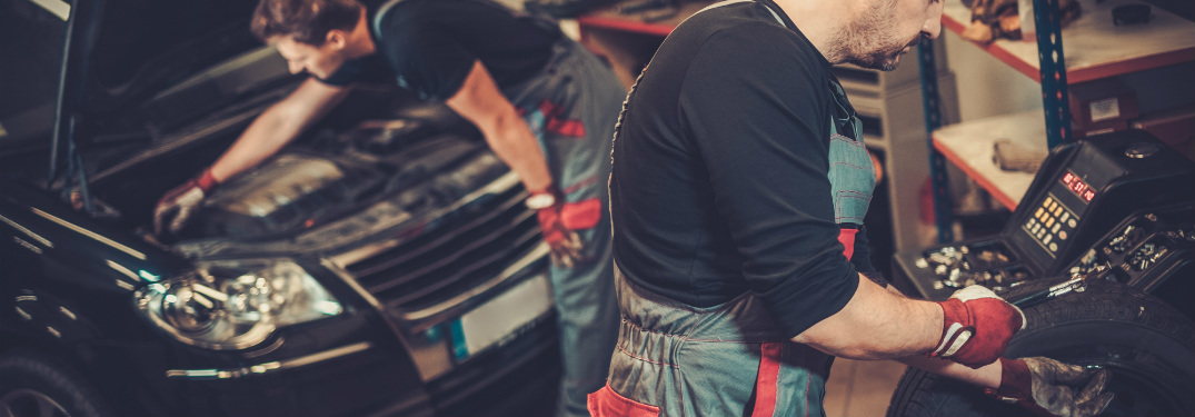 Car mechanics working in an auto body shop