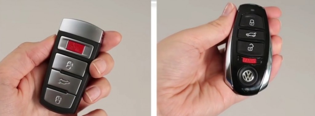 Two hands holding different styles of Volkswagen key fobs