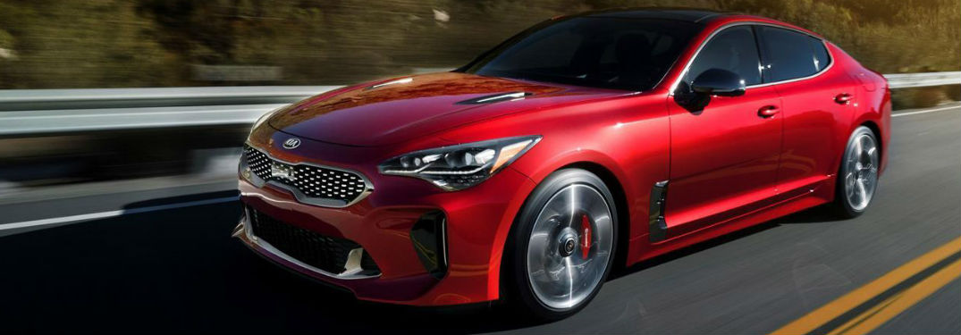 Red 2018 Kia Stinger driving down a road