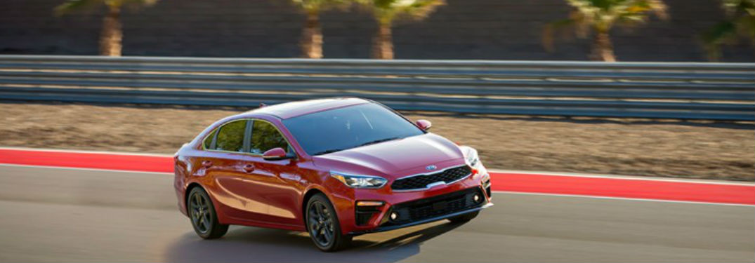 Red 2019 Kia Forte driving down a road