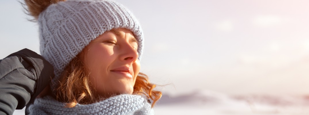 Woman wearing a knit hat and scarf in the winter