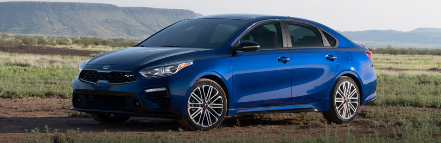 Blue 2020 Kia Forte parked on a grassy field