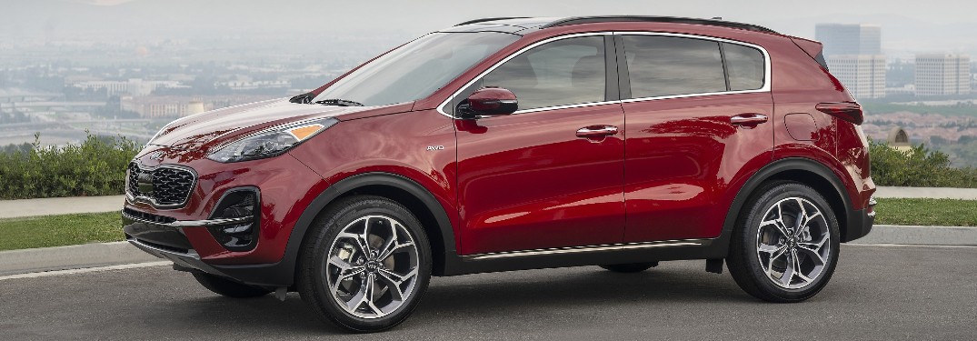 Red 2021 Kia Sportage with a city skyline in the background