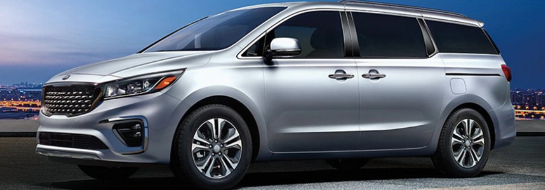 Silver 2021 Kia Sedona with a city skyline in the background