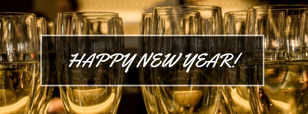 Row of Filled Champagne Glasses with White Happy New Year Script