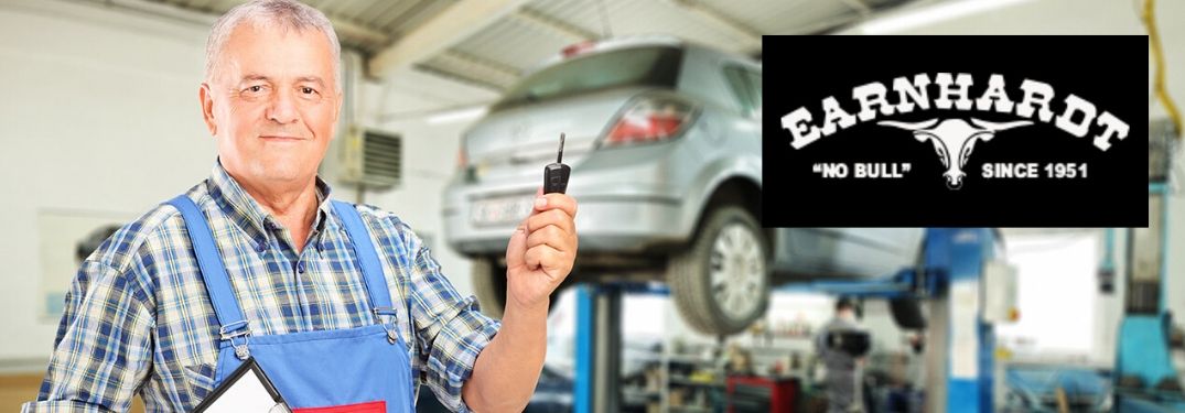 Mechanic Holding a Key in a Garage with Black and White Earnhardt Bull Logo