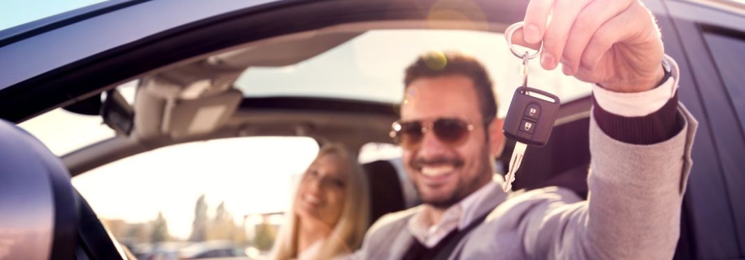 Happy Couple Holding Keys in a New Car
