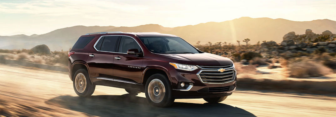 Passenger side exterior view of a red 2018 Chevy Traverse