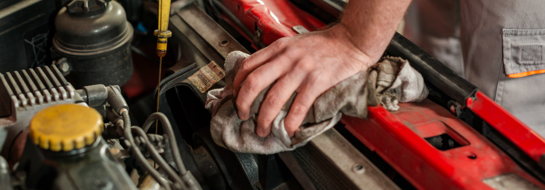Automotive technician performing an oil change on a car